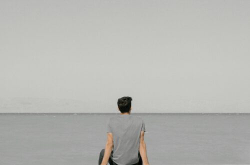 Mężczyzna siedzący samotnie nad wodą, symbolizujący stres i potrzebę wyciszenia