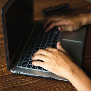 Dłonie osoby porządkującej pliki na laptopie