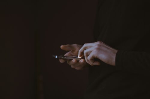 Mężczyzna trzymający telefon w dłoniach – jak przestać marnować czas na telefonie